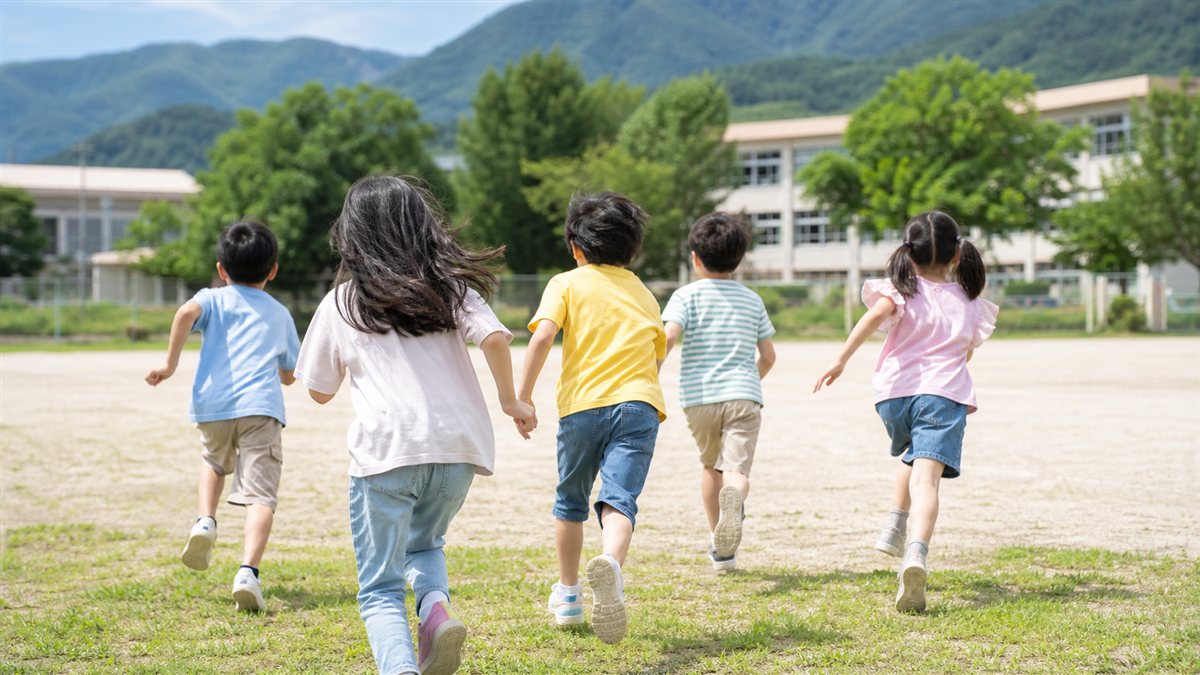 屋外で自由に活動する小学生たちの後ろ姿